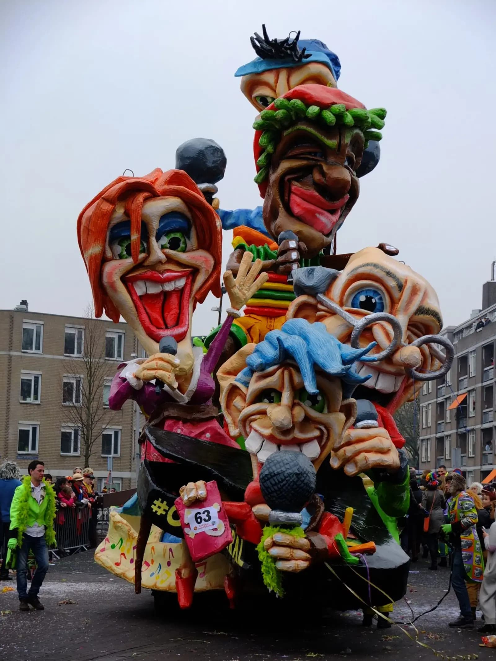 A tall carnival float with big painted faces in the Kielegat parade in Breda