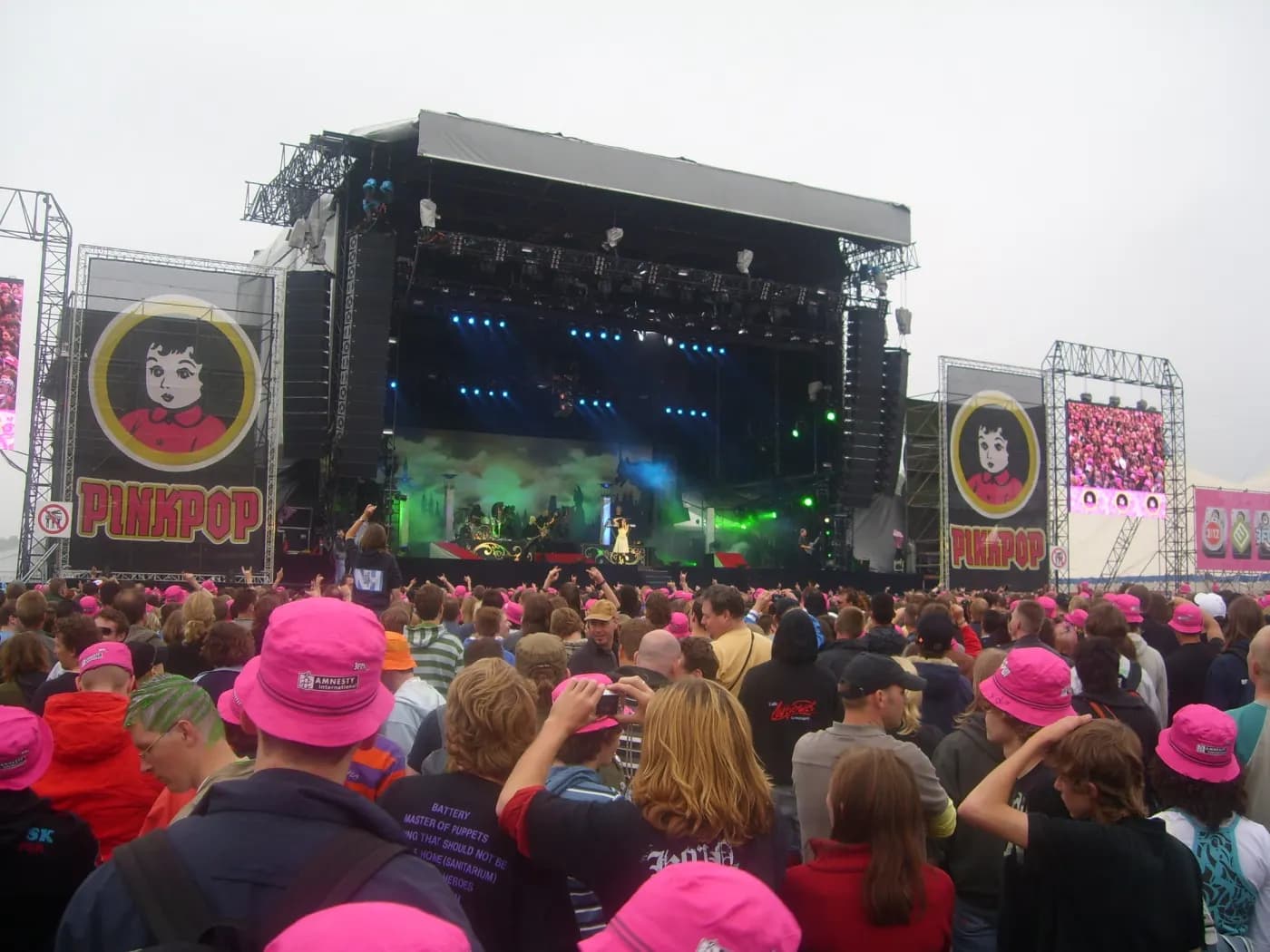 A crowd in pink hats in front of the Pinkpop main stage
