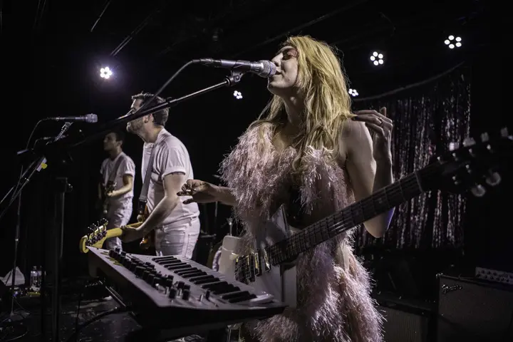 A band playing on the 7th St Entry stage in front of a glittering curtain, with a keyboard and microphones in the foreground