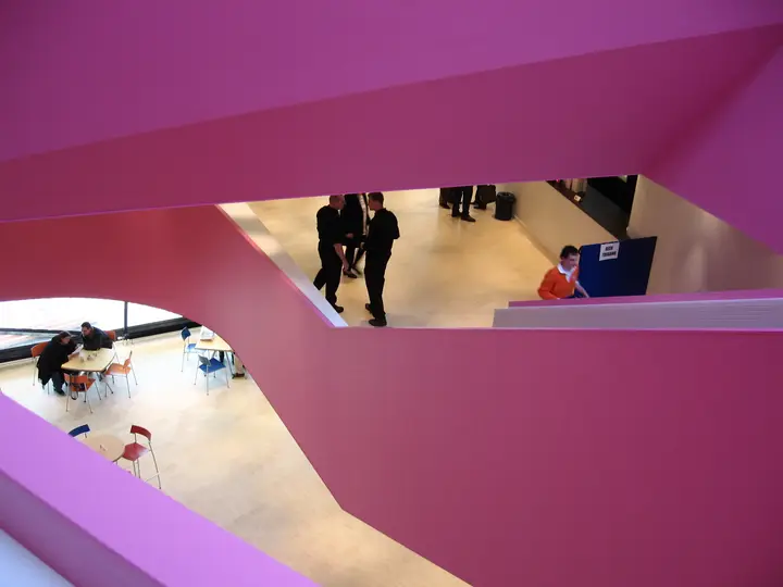 The foyer of AGORA Theater Lelystad, with the white and pink interior that leads visitors to the two halls.