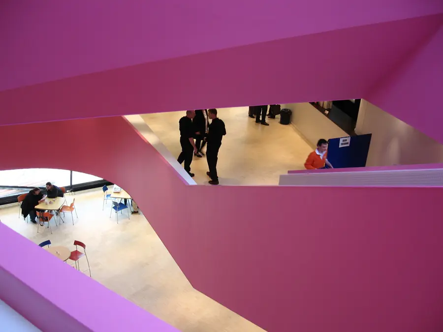 The foyer of AGORA Theater Lelystad, with the white and pink interior that leads visitors to the two halls.