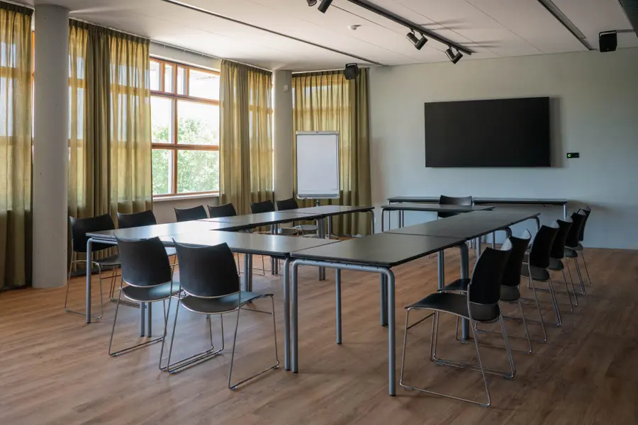 The empty Ambachtzaal Petit at C.C. Cascade, with its black chairs and dark-topped tables.