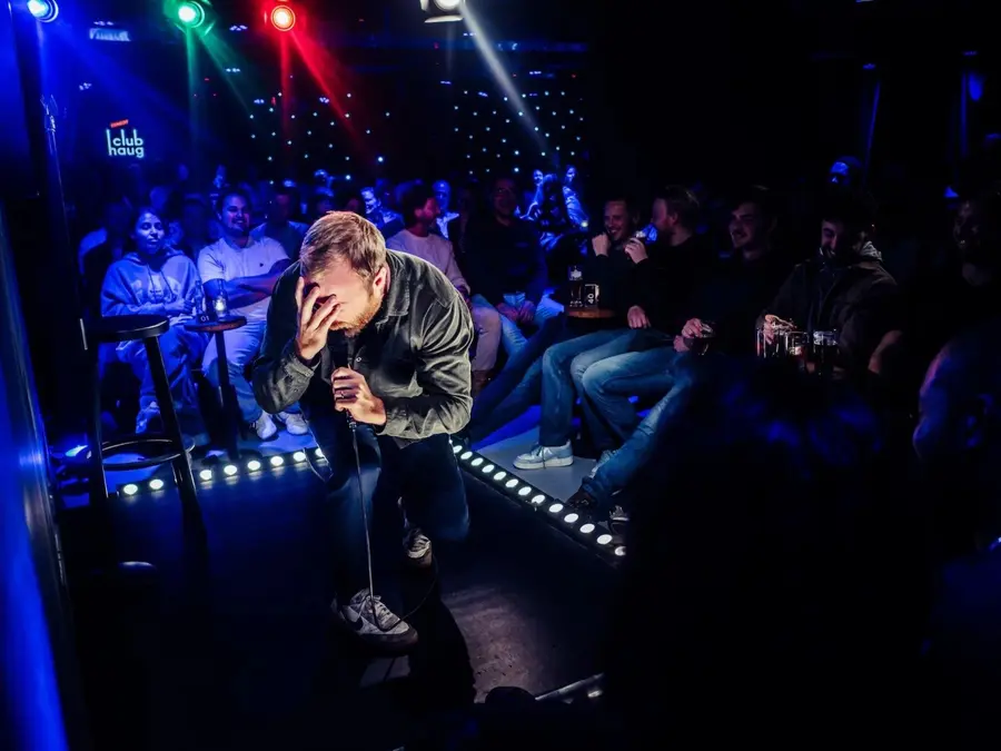 A comedian performing on stage at Comedy Club Haug.