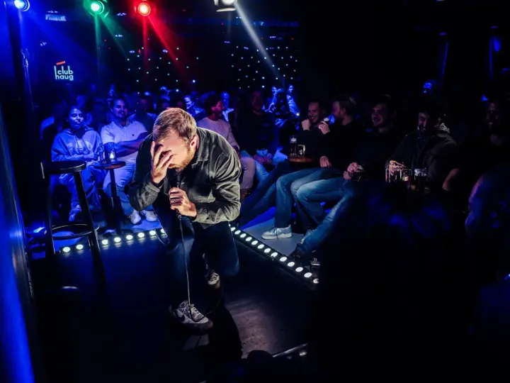 A comedian performing on stage at Comedy Club Haug.