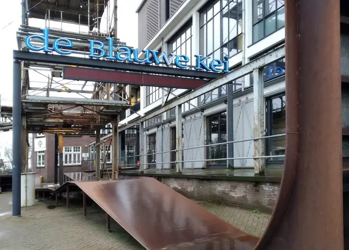The entrance of De Blauwe Kei on the Noordkade in Veghel, with the blue illuminated letters of the theatre's name.