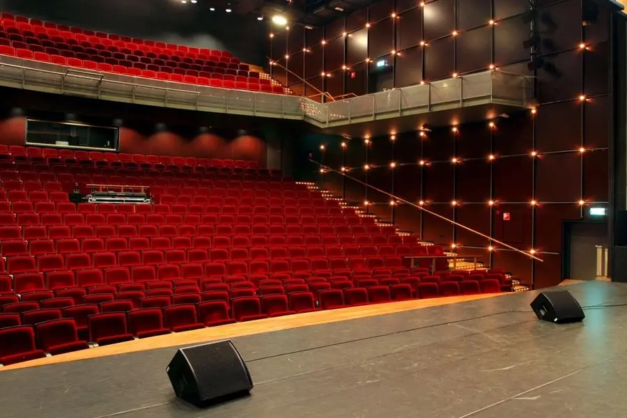 The empty Grote Zaal at De Meerpaal, with red seats and a stage