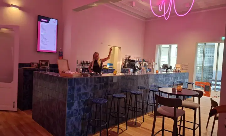 The cafe of De Nieuwe Vorst, with tables, chairs and the bar where drinks are served before shows