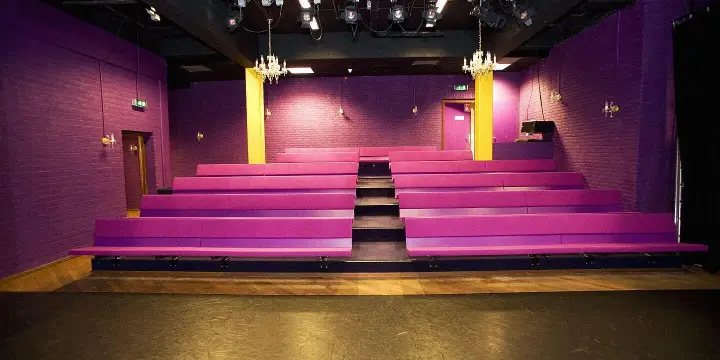 Empty Karolingenzaal with pink benches and theatre lighting
