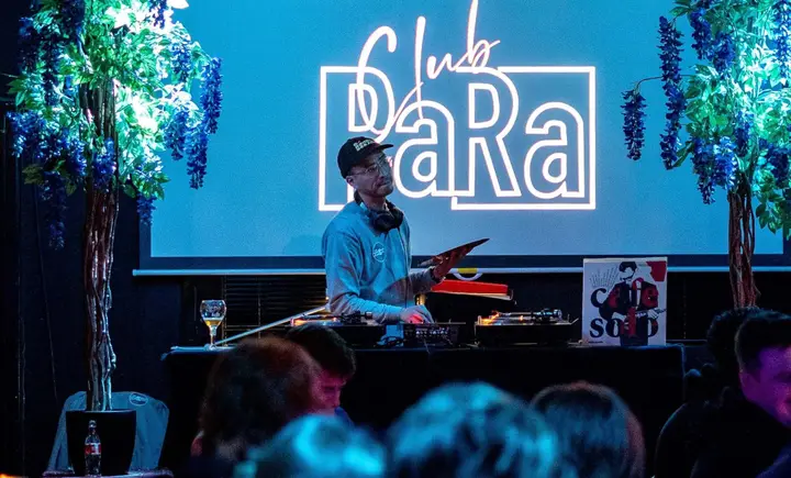 A Club PARA night at Paradox in Tilburg, with people sitting with drinks in the venue's living-room-style hall.