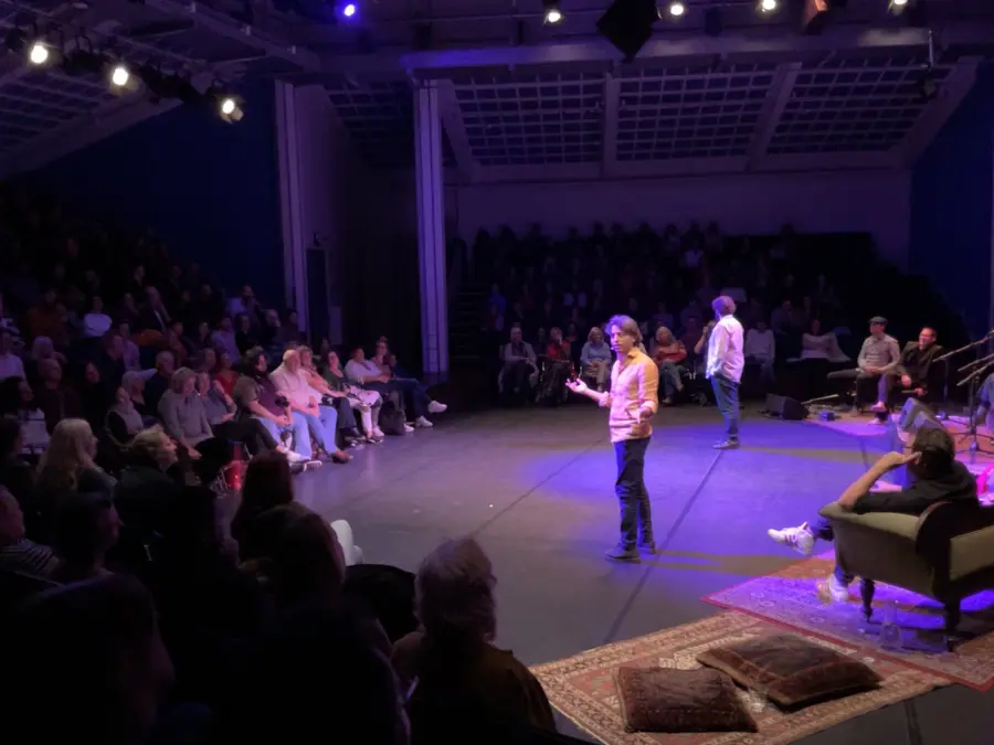 Two storytellers on stage before an audience at the opening of the Amsterdam Storytelling Festival in Podium Mozaïek.