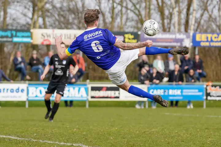 A football match between VV Buitenpost and Noordscheschut at Sportpark De Swadde.