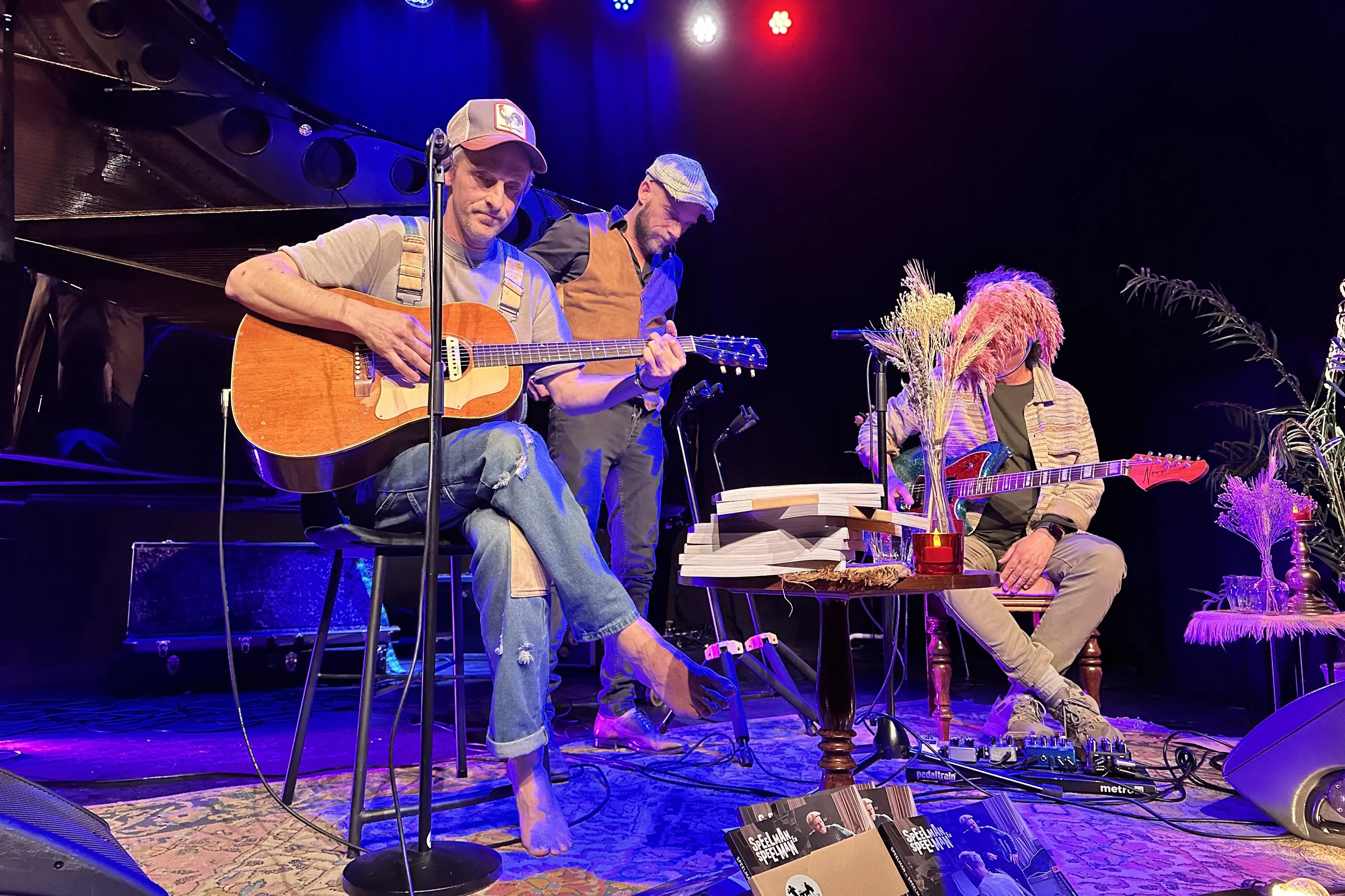 Three musicians on stage during a 2024 performance in the hall of Theater de Liefde in Haarlem, a grand piano behind them.