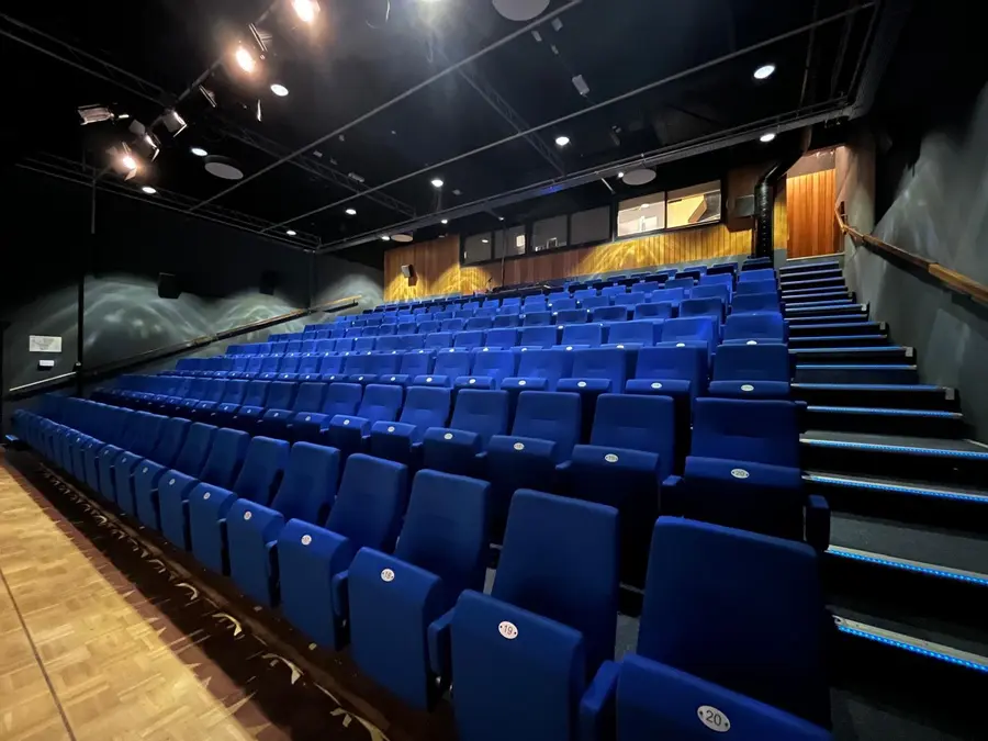 Rows of empty seats in the Grote Zaal of Theater De Omval, seen from the stage edge