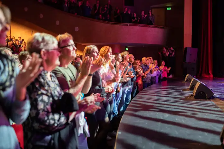 An audience applauding during a performance at Theater Sneek.