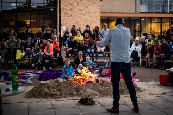 A storytelling performance in the main hall of Theater ’t Mozaïek, with the audience around the stage.