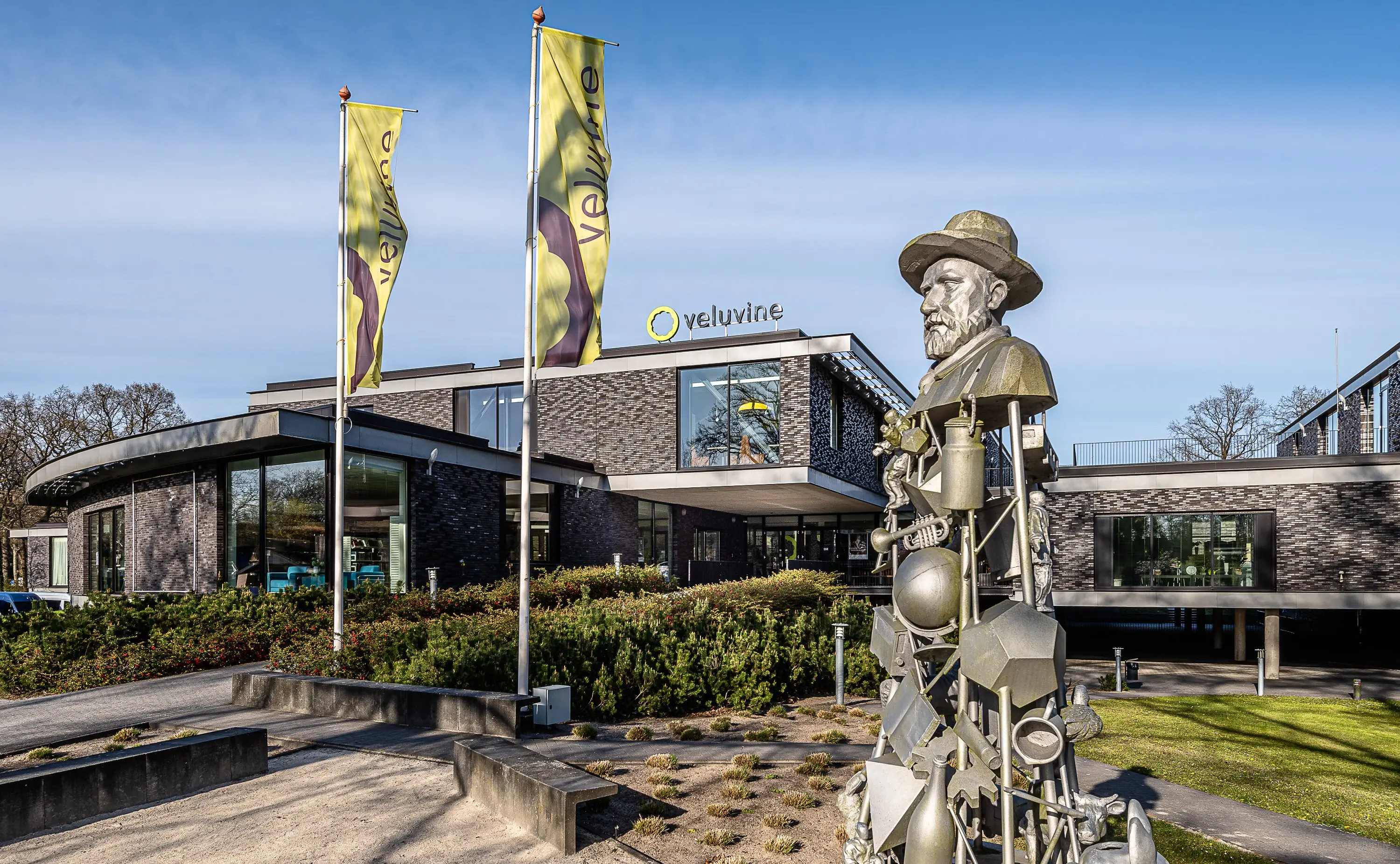 Veluvine's brick façade on the F.A. Molijnlaan, with the Molijn statue in front
