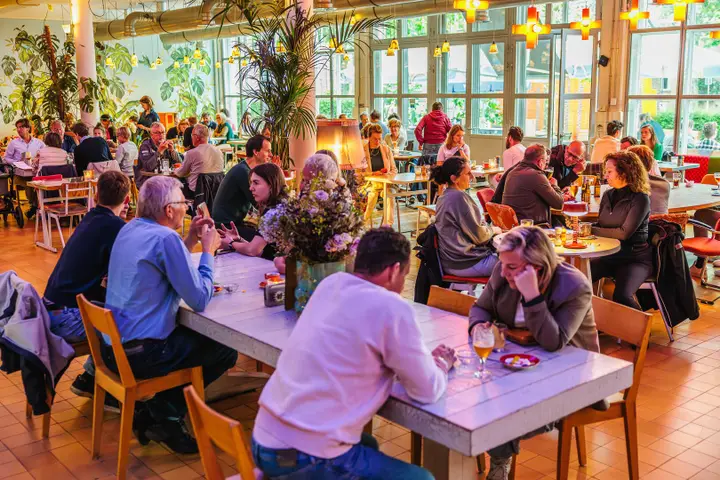 The busy café-restaurant of Verkadefabriek, with visitors at the tables.