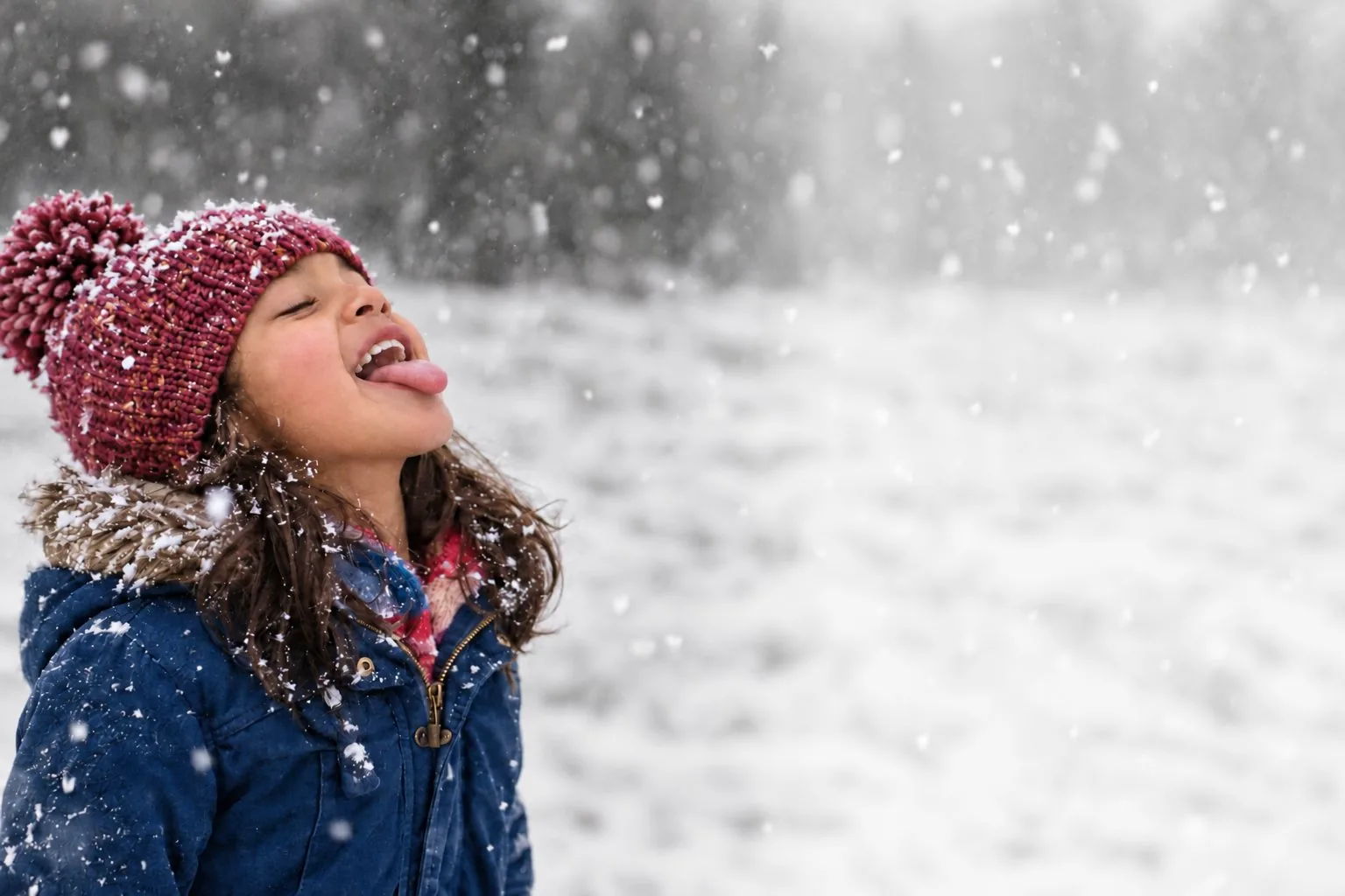 AI image: a girl in a knitted hat catches snowflakes on her tongue